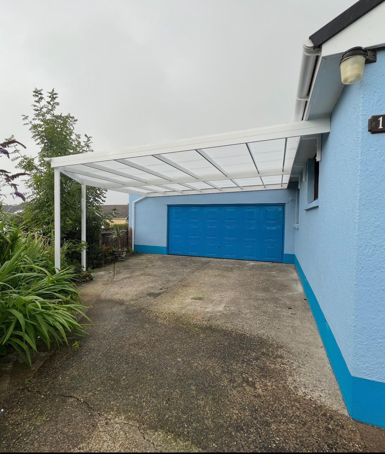 White aluminium canopy fitted beside a garage and driveway