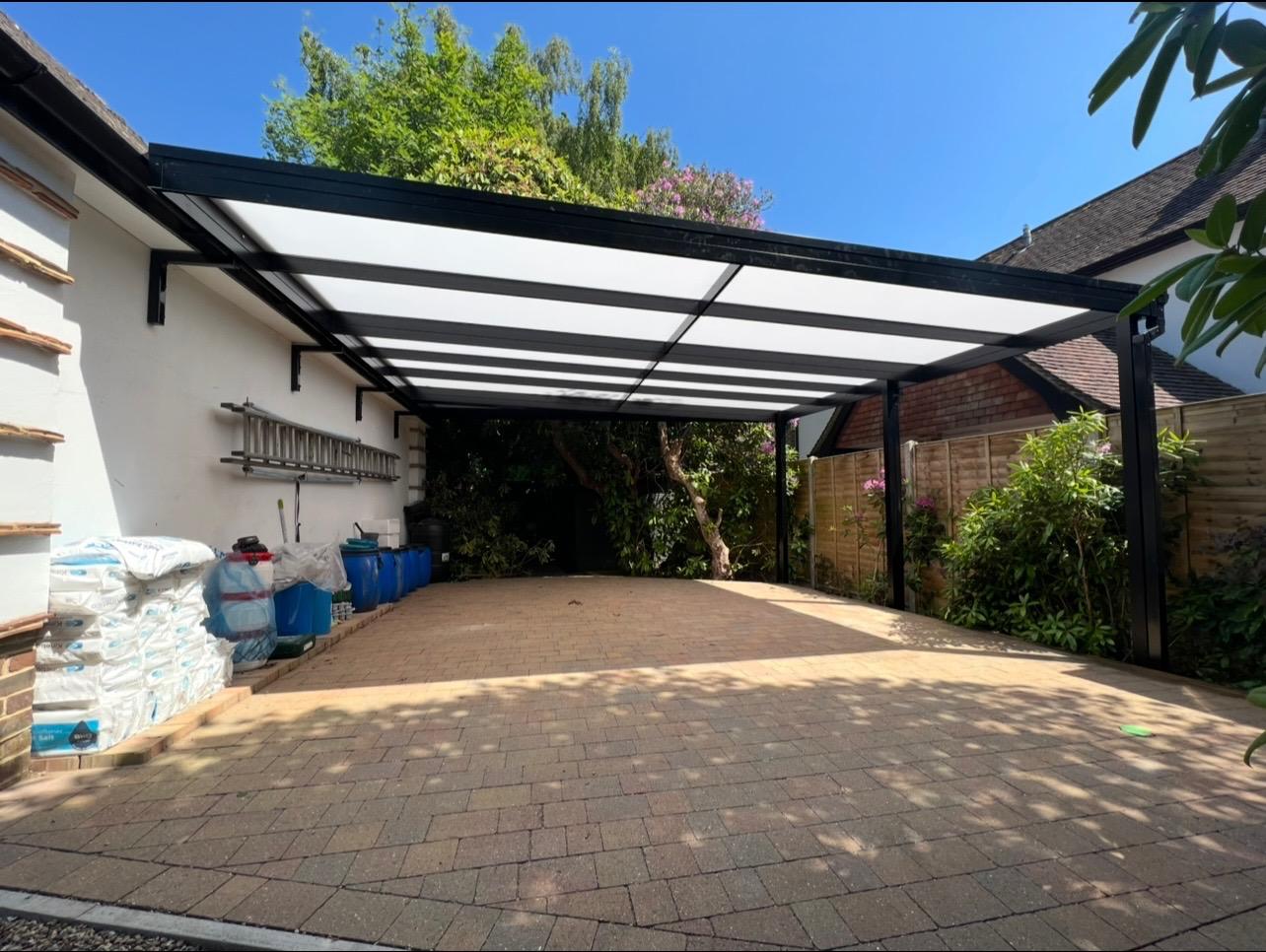 Residential patio cover with black frame and translucent roof panels