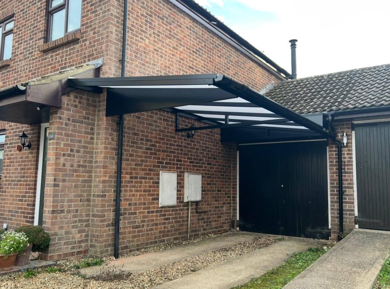 Black aluminium entrance canopy fitted above a residential doorway