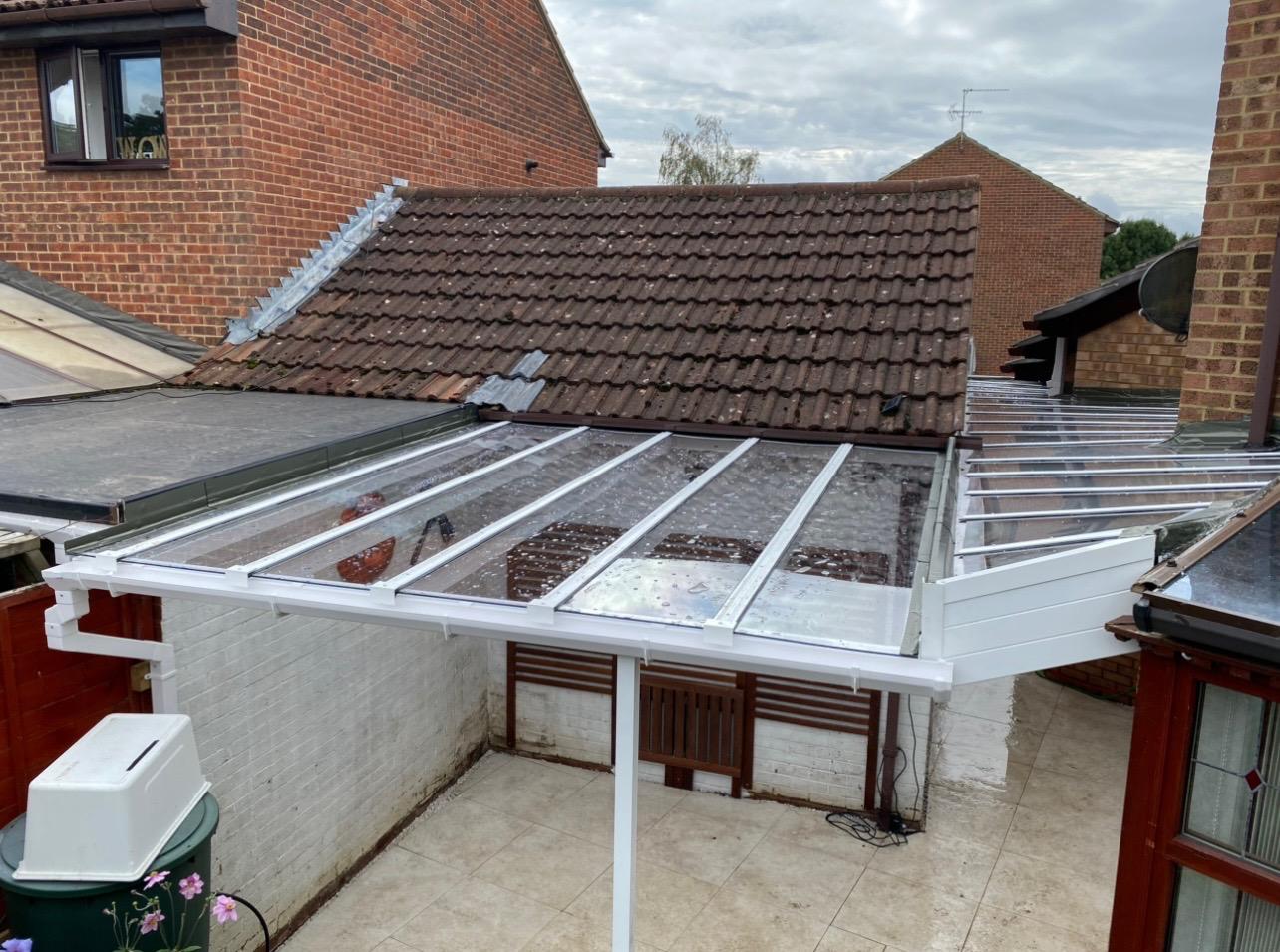 White aluminium lean-to veranda canopy over a residential outdoor space